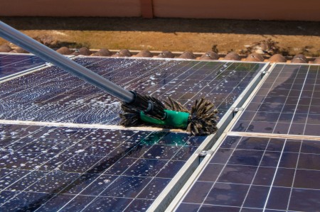 solar-worker-cleaning-photovoltaic-panels-with-brush-water-photovoltaic-cleaning.jpg