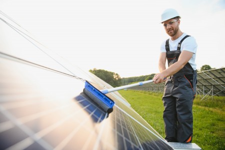 worker-cleaning-solar-panels-after-installation-outdoors.jpg